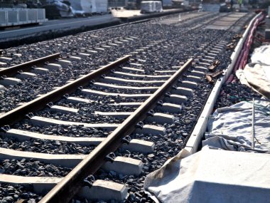 İki tramvay rayında çataldaki seviyelendirme cihazlarını kullanarak yeni ve kesin raylar döşemek. Üstlerine beton örtüler konmuş çakıl taşları... kauçuktan yapılmış kauçuk anti-titreşim tabanı