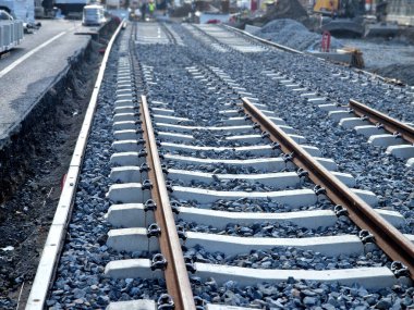 İki tramvay rayında çataldaki seviyelendirme cihazlarını kullanarak yeni ve kesin raylar döşemek. Üstlerine beton örtüler konmuş çakıl taşları... kauçuktan yapılmış kauçuk anti-titreşim tabanı