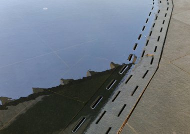 Halka açık alanda zemini kaplayan düşük seviyeli bir çeşme. Su taşkınlığı ızgarası olan bir kanal tarafından kontrol edilir. Serbest bırakıldıktan sonra normal asfalt bir gezinti alanı var. Su birikintisi, dalış havuzu