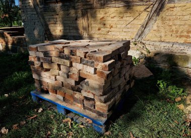 kamış sapları kireç alçısının tutamayacağı şekilde kirişe çekiçlenir. Ev tadilatı için yarı keresteli taş işçiliği.