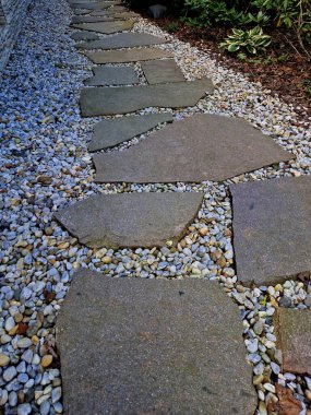 Çimlerde taş levhalar, çim biçimli kamp alanı şekilli bir masa, şehir bankı ve göl. geniş bloklar, piknik, şömine, barbekü, park, 