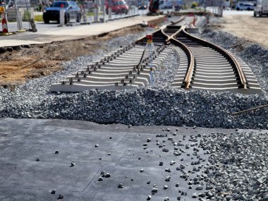 İki tramvay rayında çataldaki seviyelendirme cihazlarını kullanarak yeni ve kesin raylar döşemek. Üstlerine beton örtüler konmuş çakıl taşları... kauçuktan yapılmış kauçuk anti-titreşim tabanı