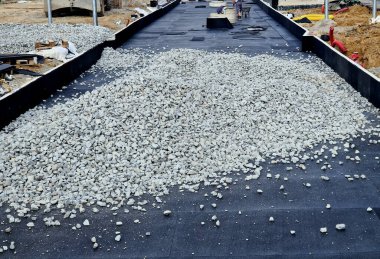 İki tramvay rayında çataldaki seviyelendirme cihazlarını kullanarak yeni ve kesin raylar döşemek. Üstlerine beton örtüler konmuş çakıl taşları... kauçuktan yapılmış kauçuk anti-titreşim tabanı
