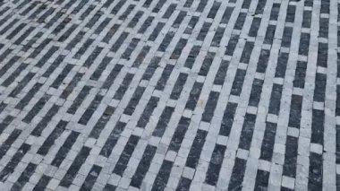 striped white mosaic tile marble. gray stripes sidewalk with walls of gabion baskets around. gray metal garden gate. low fencing for children and dogs. Kindergarten playground