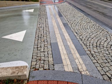 Yol kenarına işaretler çizilmiş. Durmaması gereken ve park etmemesi gereken zebra. Yeşil plastik direklerin desteğiyle asfalt. Bu direkler esnek kauçuktan yapılmıştır, böylece dövebilirler, kırmızı asfalt.