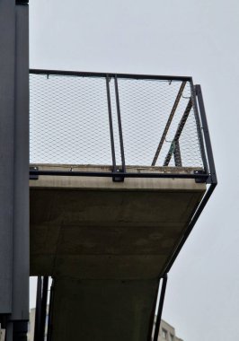 Balkonlu ön cephede tüm binayı kaplayan gergin bir kablo ağı var. Elektrik gerilim yalıtıcıları. Binanın köşeleri kemer şeklinde, yuvarlak. Örgülü ağ. çakıl