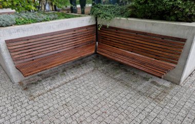 Kare tuğla saksı. Yüzey su geçirmez alçı malayla gerilmiş. Kenarında damlayan bir gölgelik bulunan metal bir levha var. Çiçek yatak kabı duvarına bağlı bir bank. çalıName