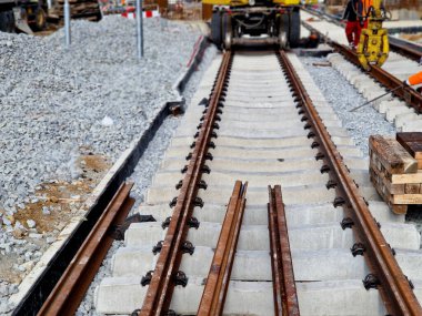 İki tramvay rayında çataldaki seviyelendirme cihazlarını kullanarak yeni ve kesin raylar döşemek. Üstlerine beton örtüler konmuş çakıl taşları... kauçuktan yapılmış kauçuk anti-titreşim tabanı