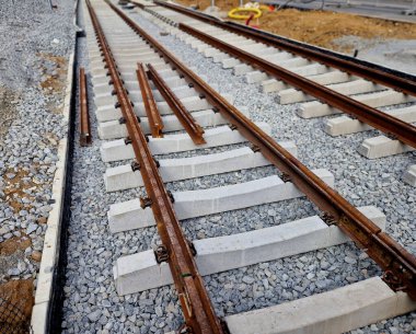 İki tramvay rayında çataldaki seviyelendirme cihazlarını kullanarak yeni ve kesin raylar döşemek. Üstlerine beton örtüler konmuş çakıl taşları... kauçuktan yapılmış kauçuk anti-titreşim tabanı