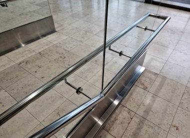 Tırabzanın kenarı U şeklindeki şeritle kaplıydı. Parlak paslanmaz çelik borudan yapılmış korkulukların şeffaf dolguları. Binaya girin.