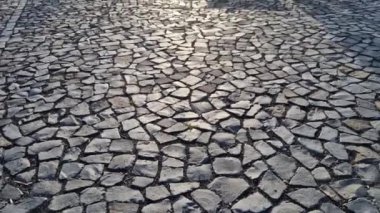 Kare şeklindeki silindirde taş bariyerler ve üstünde de bir yarımküre var. Granit kaldırımlar otoparkta duruyor. Zincirleme çit, yayalar ve taşlı araçlar kolonisine karşı.
