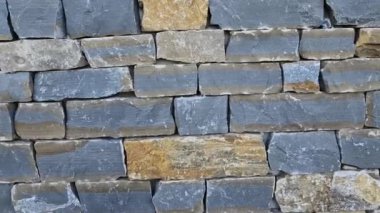 Modern gri kahverengi, bej renkli, metal kapaklı, taş kaplamalı bir ev. Asfalttaki su kanalını boşaltmak için. kireçtaşı kaplama