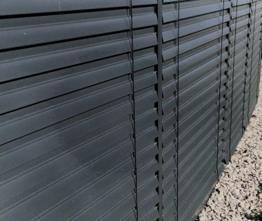 Binalarda panjur servisi. Metal çatalların ayarlanması, ayarlanması ve bakımı. Perdeleri kapalı bir ofis penceresi. Gri metal kapı kapağı. Güneş koruması, dükkan önü, servis