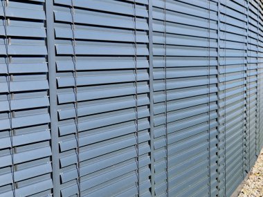 Binalarda panjur servisi. Metal çatalların ayarlanması, ayarlanması ve bakımı. Perdeleri kapalı bir ofis penceresi. Gri metal kapı kapağı. Güneş koruması, dükkan önü, servis