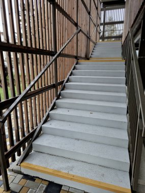 the concrete staircase next to the facade of the building does not have a handrail. it is a simple concrete casting. the black building has fire emergency escape routes from the roof of the building clipart