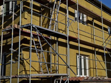 repair of the facade of the house. The scaffolding is covered with a blue transparent net made of plastic fabric. protects settlers as well as pedestrians so that pieces of concrete bricks and objects