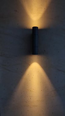Leke duvar ışığı evin dış cephesini gece koni şeklinde aydınlatıyor. Akşam konumu ve seyrüsefer lambası Gabion duvarında iki yönde parlıyor, toz boyalı.