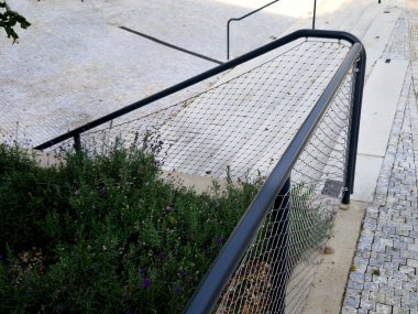 Kalkmış betondan yapılmış bir yatakla bölünmüş geniş bir merdiven. Tırabzanda borulardan yapılmış saplar ve paslanmaz çelik ağ kablosundan yapılmış bir ip var.