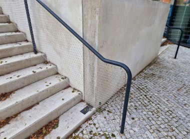 Kalkmış betondan yapılmış bir yatakla bölünmüş geniş bir merdiven. Tırabzanda borulardan yapılmış saplar ve paslanmaz çelik ağ kablosundan yapılmış bir ip var.
