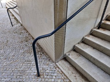 Kalkmış betondan yapılmış bir yatakla bölünmüş geniş bir merdiven. Tırabzanda borulardan yapılmış saplar ve paslanmaz çelik ağ kablosundan yapılmış bir ip var.