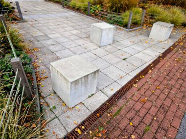 Asfalt kaldırımdaki çimen küplerini korumak için beton bariyerler. Disiplinsiz sürücüler park engelini aşamaz ve off-road 'a girmek için para ödemek zorundalar.