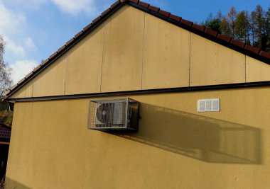 Arka bahçede, dağlarda bir kulübede soğutma ünitesi. Taş duvar ve ahşap kaplama. Yazın klima, ayar, koruma ağı, kablo gibi ısıtma ve soğutma enerjisi tasarrufu sağlar