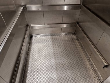 Asansörün girişindeki koruyucu çerçeve. Palet kamyonlarının paslanmaz çelik kapılara çarpmasını engeller. Kızakların yardımıyla ortadan yönetir. Tamir masrafları kaydedilecek