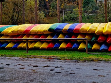 Nehir kıyısında plastik tekne kiralamış. Mevsim dışı ya da kötü havada tekneler zincirlenip yığılır. Hasarlı kanolar tamir ediliyor