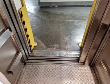 Asansörün girişindeki koruyucu çerçeve. Palet kamyonlarının paslanmaz çelik kapılara çarpmasını engeller. Kızakların yardımıyla ortadan yönetir. Tamir masrafları kaydedilecek