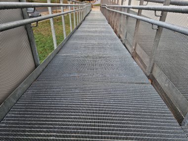 metal railings and metal grid on the floor. instead of stairs, there is a ramp for wheelchair users, a net, galvanized material. wheelchair lift. residential building, hospital entrance, senior, 