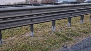 Yapısal gözenekli panellerden oluşan gürültü bariyeri. Gri ve gümüşi koruyucu çitler gürültülü bir yoldan evleri ayırıyor.  