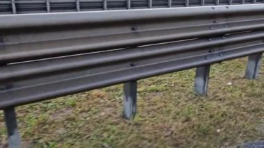 Yapısal gözenekli panellerden oluşan gürültü bariyeri. Gri ve gümüşi koruyucu çitler gürültülü bir yoldan evleri ayırıyor.  