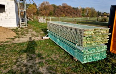 boards stacked in a pile straight from the sawmill. green stain is a protection against wood rot. fungal decay without fungicide damages the structure  clipart