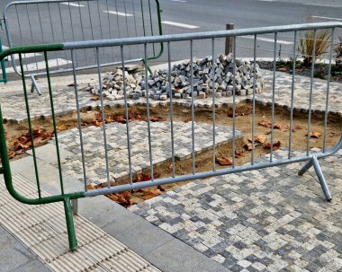 Bir tiler hasarlı kaldırımları tamir eder. Düzeltilmiş mermer küplerle mozaik