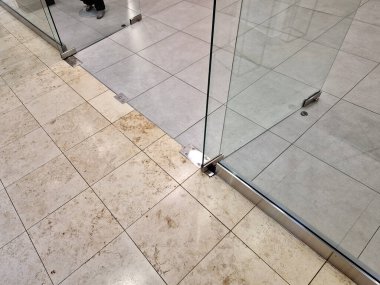 Çerçevesiz cam kapı. Camlı bölmelerin özel menteşeleri ve sapları vardır. Her şey cama kazınır ve paslanmaz çelik vidalarla tutturulur. parlatılmış bar kolu