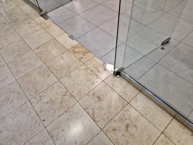 Çerçevesiz cam kapı. Camlı bölmelerin özel menteşeleri ve sapları vardır. Her şey cama kazınır ve paslanmaz çelik vidalarla tutturulur. parlatılmış bar kolu