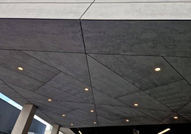 Tavandaki spot ışıkları çatıdaki çıkıntının altında. Endüstriyel eklemli çimento yonga, vs.