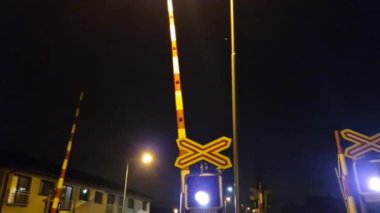 Yükseltilmiş bariyerler açık ama tren geldiğinde ışıklar yanıp sönüyor. Şoför tren raylarının güvenliğine saygı göstermeli, beyaz.