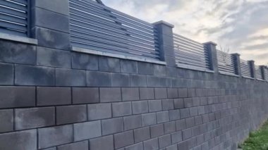 Beton bloklardan oluşan çitin metal dolguları. Metal bir alüminyum çit bahçede mahremiyet sağlayacak. Yatay kirişler iyi korunuyor. Tuji 'den yapılmış bir çit koruma sağlar.