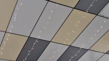 large glass shop windows with an overhang of the roof are a mirror of the foothill landscape. metallic gold. wall and ceiling cladding sheets attached with rivets. halogen light in ceiling pattern