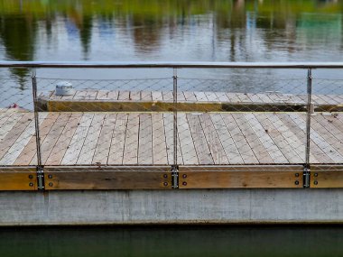 Beton zeminde metal çubukların yanında yüzen beton iskele var. Zincirler ve halatlar sel ihtimaline karşı sigorta olarak. Tahta paneller ve parmaklıklar gibi kalın örgüler.
