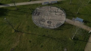 Yuvarlak sallanan sandalye, bahçedeki sütunlar arasında destekli kenevir iplerden yapılmış hamak alçak çitle çevrili ve geminin halatından yapılmış bir kiriş zeminin üzerinde asılı.