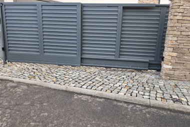 Sürgülü kapı kendi kendine katlanıyor. Küçük alan, kapının sokaktan girişteki küçük bir avluya monte edilmesini gerektiriyor. alüminyum levhalar