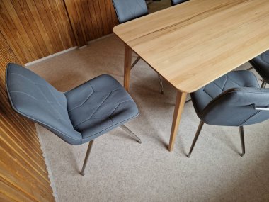 Kayın ağacından yapılmış ev yemeği masası. 8 sandalyenin etrafında döşeme ve geometrik dikişler var. Reklam amaçlarına uygun masa örtüsü olmayan boş bir masa üstü..