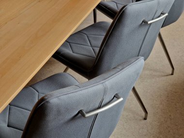 Kayın ağacından yapılmış ev yemeği masası. 8 sandalyenin etrafında döşeme ve geometrik dikişler var. Reklam amaçlarına uygun masa örtüsü olmayan boş bir masa üstü..