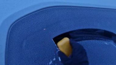 Adam kışın camları ve arabaları temizliyor. Kayak yapmadan önce, önden ve yandan görüş açınızı açmalısınız, aksi takdirde kaza riski var. Rahatlamak için eldiven daha uygun olur.