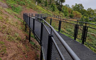 Parkın arazisi engelli insanların tekerlekli sandalyede hareket etmesine izin vermiyor. Şehir kalenin altına bariyersiz metal rampalar ve köprüler inşa etti. Bakış açısına gel.