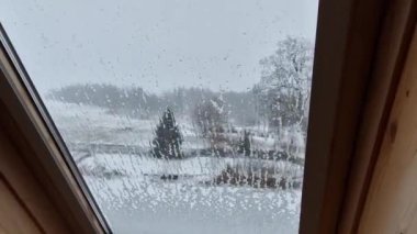 Tavan penceresindeki lekeler dağların manzarasını engelliyor. Manzara karla kaplı ve eriyor.