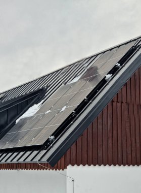 Dağlardaki çatıyı kaplayan güneş panelleri sayesinde ormandaki kendi kendine yeten yazlık ev. Kendi kullanım için üretim. İskandinav asıllı İskandinav yalnız yaşıyor, metal çatılı.