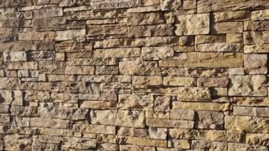 Modern gri kahverengi, bej renkli, metal kapaklı, taş kaplamalı bir ev. Asfalttaki su kanalını boşaltmak için. kireçtaşı kaplaması, genişleme eklemleri, genişleme boşluğu